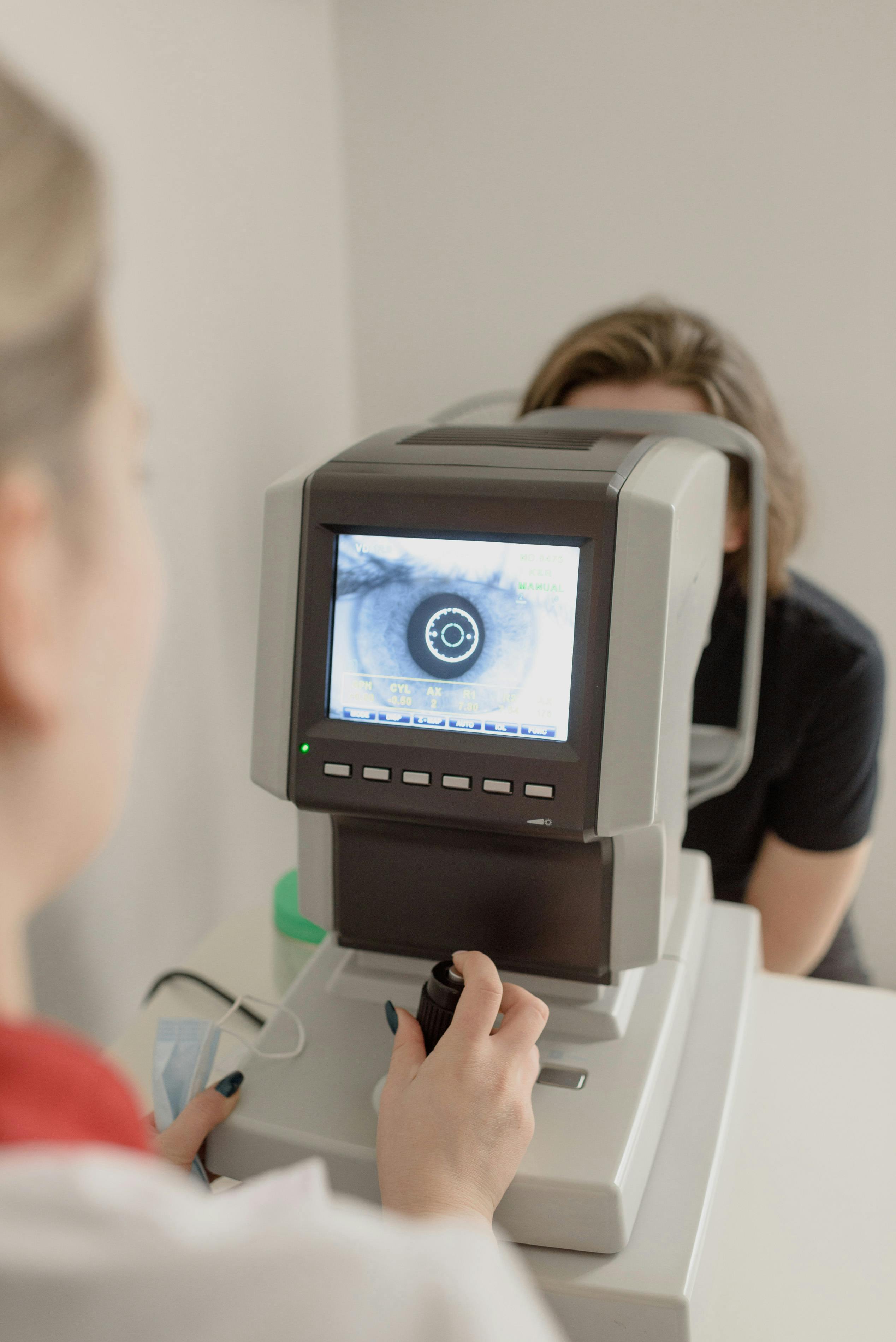 Eye care professional working with clinical examination equipment