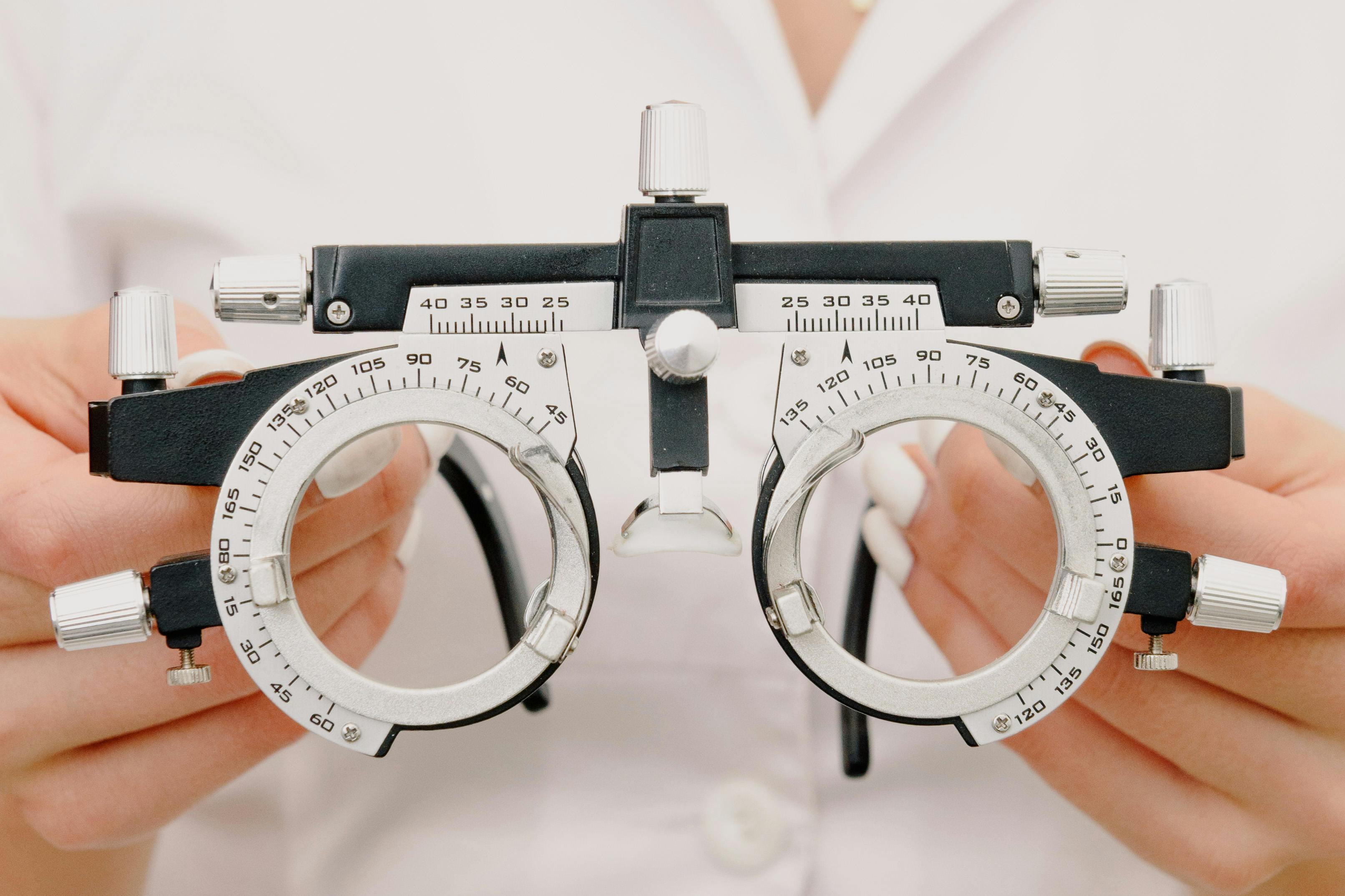 Eye care professional working with ophthalmic examination equipment